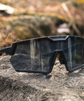 Light Adapting Transition Lenses For Serious Sun Glare Blocking Safety Glasses With Ansi Z87 Certification clear to dark shades on rocky surface.