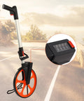 Fabater Measuring Wheel, 0 9999 9m or 0 9999 9ft Range Hand Measuring Wheel with a black and orange design on a road.