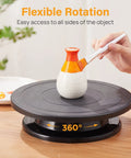 Person painting a ceramic on an 11 Inch Rotate Turntable For Cake Decorating And Painting With Smooth Ball Bearing Spin And 360 Degree Rotation Black Lightweight Display Stand For Spinning Spraying Decorating And Sculpting Projects By Kootek.