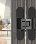 Badass Concealed Hidden Door Hinges With Rock Solid 180 Degree Adjustable Movement And A Zero Drama 80 Kilogram Load Rating For Quick Wood Door Installation In Sleek Black on a wooden door.