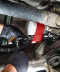 Heavy Duty Oil Filter Strap Wrench With Three Eighths And One Half Inch Drive Nylon Strap Forged Steel Handle Chrome Plated Drive in use under a truck