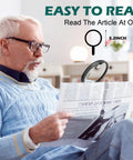 Man reading newspaper with Handheld Illuminated Magnifier With 10x 25x 45x Zoom And 12 LED Lights Three Light Modes Large Five Point Two Inch Optical Lens For Seniors Reading Coins Inspection Includes Storage Bag And Cleaning Cloth, large lens visible.