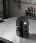Heavy Duty Black Aluminum Igt Table Track Slider Clamp Mount With Triple Sized Ports for outdoor lighting setup, shown on a metal surface.