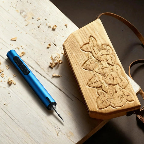 Blue mini cordless engraving pen with LED display beside a carved wooden plaque