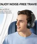Man in airplane wearing Q20i Hybrid Active Noise Cancelling Wireless Over Ear Headphones With 40 Hour Battery Life.