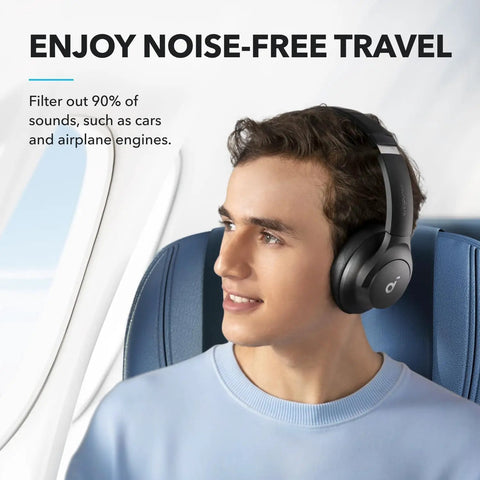 Man in airplane wearing Q20i Hybrid Active Noise Cancelling Wireless Over Ear Headphones With 40 Hour Battery Life.