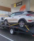 Car secured on trailer using 4 Pack Heavy Duty Car Trailer Tie Down Straps Set With 2 Inch By 10 Foot Ratchet Straps J Hooks