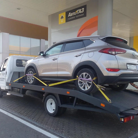 Car secured on trailer using 4 Pack Heavy Duty Car Trailer Tie Down Straps Set With 2 Inch By 10 Foot Ratchet Straps J Hooks