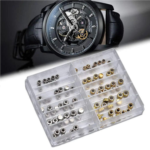 Pro Grade Watch Repair Kit With Stainless Steel Crowns And Gold Flat Head Crowns with spare parts next to a black watch.
