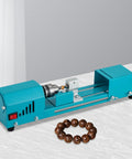 96W Portable Mini Wood Lathe Machine For Beads And Carving With Milling Accessories Wide Voltage 110V To 240V Us Plug For DIY Woodworking Projects, teal color, positioned over a white surface with wooden beads.
