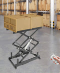 Built Like A Tank Electric Scissor Lift Table With Smooth Hydraulic Action And Wireless Remote For Easy Warehouse Material Handling Holds 180 Pounds Securely And Folds Flat For Storage with loaded boxes in a warehouse.