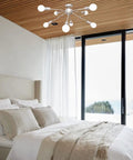 Mid Century 8 Light Sputnik Chandelier Nickel Ceiling Light Fixture in modern bedroom with wood ceiling and natural light