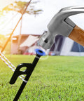 Inserting 8 Pack Heavy Duty Tent Stakes Forged Steel Camping Stakes For Ground Outdoor Canopies And Tents into grass with hammer