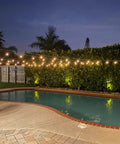 Solar Powered Outdoor String Lights 48 Ft Commercial Grade Waterproof Patio Lights illuminating a backyard pool area