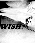 Skateboarder performing tricks in skate park with concrete ramps and graffiti art in black and white image look
