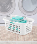 Ultra 2 Bushel Plastic Laundry Hamper Baskets, 6 Pack in White placed in front of a washing machine with folded towels inside