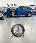 Beefy Heavy Duty Tire Dolly For Garage And Auto Repair Wheel Tire Moving Cart with car and mechanics in workshop.