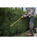 User operating Badass Cordless Hedge Trimmer Equipped With 60 Volt Lithium Battery For Knockout Yard Cleanup on lush bush.
