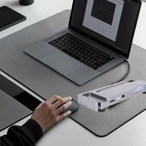 Turn Your Ordinary Laptop Into A Straight Up Gaming Beast With This External GPU Dock next to a laptop on a desk.