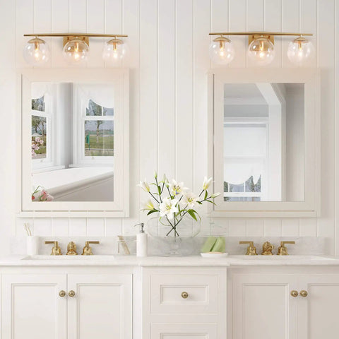 Three Light Gold Vanity Light Fixture With Clear Globe Glass Shades And Slim Taper Arm For Modern Bathroom Decor