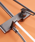 Wall Mounted Exposed Shower System with Tub Spout 90° Rotating Gun Gray faucet with top handle and water outlet on an orange background.