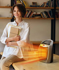 1500W Portable Ceramic Space Heater for indoor use with 3 modes on a desk in an office with a woman holding books.
