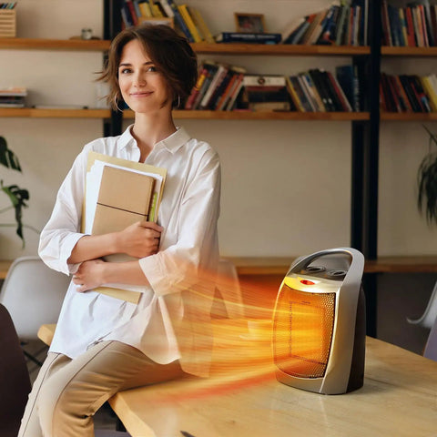 1500W Portable Ceramic Space Heater for indoor use with 3 modes on a desk in an office with a woman holding books.