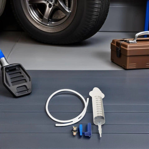 Top Notch Manual Automotive Fluid Extractor Pump For Oil Changes And Brake Fluid Service With Durable Plastic Build Plus Long Extension Tubes For Easy Car Care DIY Jobs on garage floor with tools and a tire.