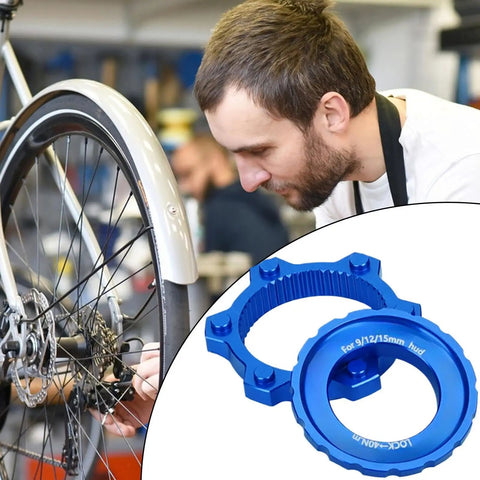 Lightweight Aluminum Center Lock Tool Adapter For Bicycles Disc Brakes next to mechanic adjusting bike wheel.