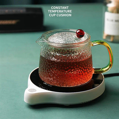 Solid Pick Mug Warmer And 200W Cup Heater That Keeps Your Daily Grind Steaming Hot Up To 100C With Five Precise Temperature Levels Plus Non Slip Base For Desk with tea-filled glass cup on heating base.