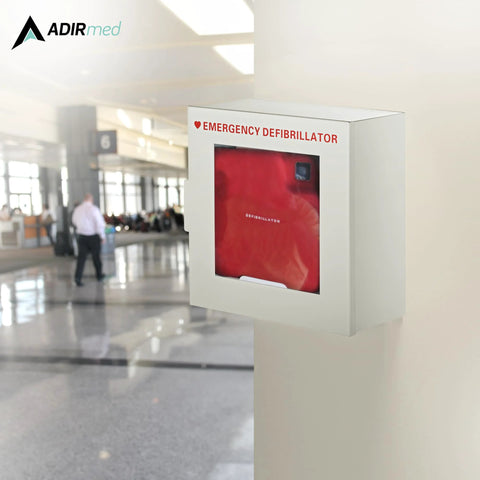 Front view of a white AdirMed AED cabinet mounted on a wall, red AED visible behind glass window.