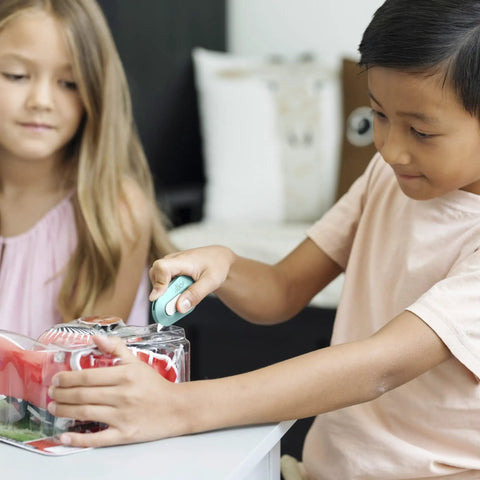 Child using Mini Box Cutter With Ceramic Blade Manual Retracting Safe Edge Opens Boxes Fast Mint Color Pack to open packaging