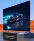 4K HDMI KVM Switch For Dual Computers Seamlessly Share One Monitor With USB 3.0 Hub Quick Toggle Keyboard And Mouse Printer On Windows Linux PS5 Xbox on a desk with a sports car image displayed.