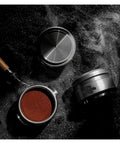 Top Shelf Espresso Tamper And Coffee Distributor Combo With Dual Stainless Ripple Blades For Dead On Bed Leveling Fits All 51Mm 53Mm And 58Mm Portafilters Sick Quality Barista Essentials Kit with a wooden handle and coffee grounds.
