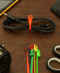 Heavy Duty Reusable Cable Ties With No Sweat Quick Release Lever Rock Solid Wire Control 275 Pound Pull Strength on table with tools.