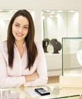 Woman standing next to ultra slim digital pocket scale on counter, 600g capacity, 0.1g increments, blue LCD, in a well-lit showroom.