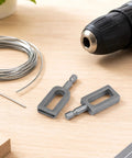 2 Piece Wire Twister Drill Bit Set 1/4 Inch Hex Shank, heavy duty steel bits next to wire and drill on wooden surface.