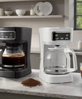 Sleek Black 12 Cup Programmable Drip Coffee Maker With Bold Brew Control Auto Timer showcasing coffee brewing on a kitchen counter.