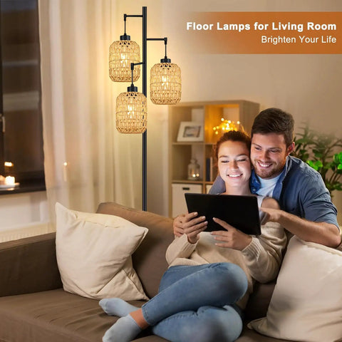 Couple using tablet beside Boho Rattan Tree Floor Lamp With Three Edison Bulbs, Industrial Black Standing Farmhouse Style lamp.