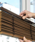 Premium Clear Double Slat Valance Clips To Tuck Away Mini Blind Brackets with brown mini blinds being adjusted near a window.