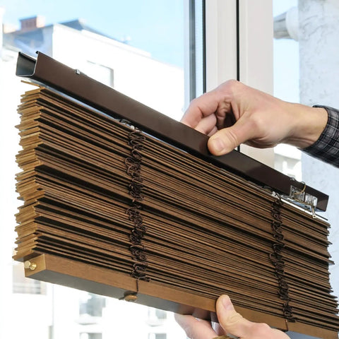 Premium Clear Double Slat Valance Clips To Tuck Away Mini Blind Brackets with brown mini blinds being adjusted near a window.