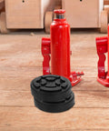 Vosarea Heavy Duty Car Lift Pads Set Of Four Round Auto Jacking Rubber Mats for Two Post Hoist placed near red jacks on wooden floor.
