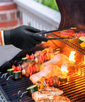 Person using Dual Layer Heat Resistant BBQ Gloves With Nitrile And Cotton Liners 10 Mil Thick Non Slip Grip For Grilling Smoking And Handling Hot Meat
