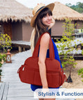 Woman holding maroon lightweight travel duffel bag with wet pocket, dual straps, on beach path for weekender journeys.