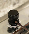 Danco 80360 faucet grease cap on a chrome faucet stem; black threaded plastic cap