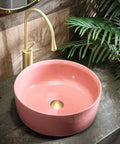 Top Shelf 15.7 Inch Round Pink Ceramic Vessel Bathroom Sink Over Counter Vanity Basin With Super Easy Pop Up Waste Kit Slick High Gloss Glaze Hits Different For Any Modern Home Space, shown from the side with faucet.