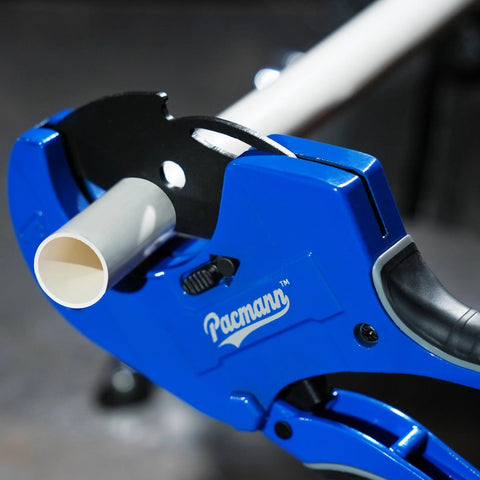 Pacmann blue PVC pipe cutter with white PVC pipe inserted, front close-up view