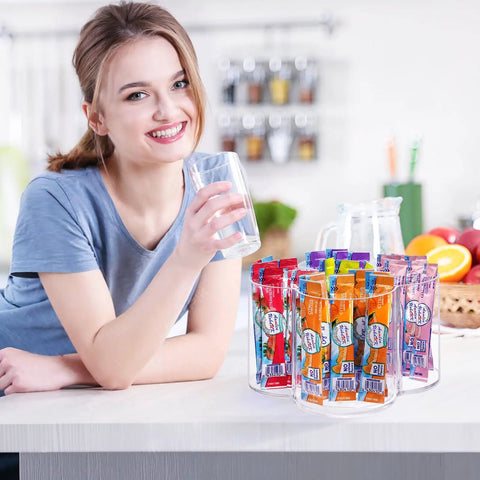 Happy person enjoying a drink beside a 360 Rotating Drink Packet Organizer Acrylic Lazy Susan with beverage mixes.