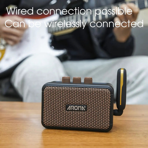 Aroma Mini 5W Guitar Amp With Clean And Overdrive Channels, Rechargeable Portable Electric Guitar Amp AG 04 on table
