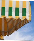 Yellow striped canvas awning against blue sky, suitable for use with Heavy Duty Canvas Repair Tape For Awnings Tents And Boat Covers With Strong Adhesion Wear Resistant Quick Fix For Outdoor Gear And Equipment Ideal For Roofs Sails Tents Tarpaulins And Marine Gear.